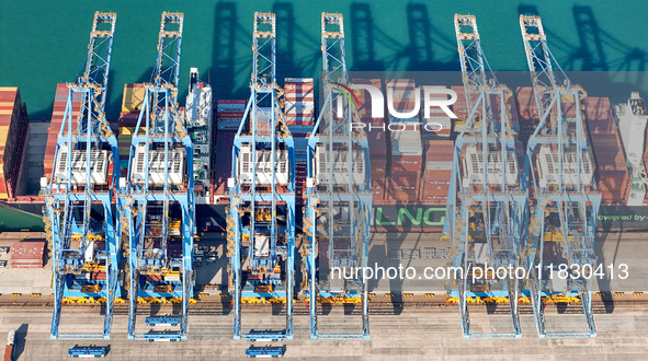 A cargo ship loads and unloads cargo at the fully automated terminal of Qingdao Port in Qingdao, China, on December 3, 2024. 