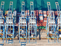 A cargo ship loads and unloads cargo at the fully automated terminal of Qingdao Port in Qingdao, China, on December 3, 2024. (