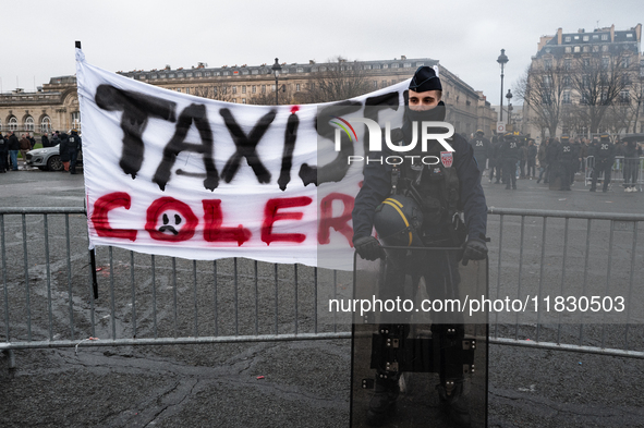 French Republicain Security Corps (CRS) officers face taxi drivers at the Invalides. Taxi drivers gather at the Invalides during a demonstra...