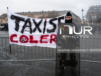 French Republicain Security Corps (CRS) officers face taxi drivers at the Invalides. Taxi drivers gather at the Invalides during a demonstra...