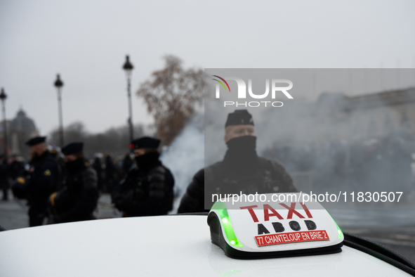 Taxi drivers gather at the Invalides in Paris, France, on December 3, 2024, during a demonstration against a new downward pricing system for...