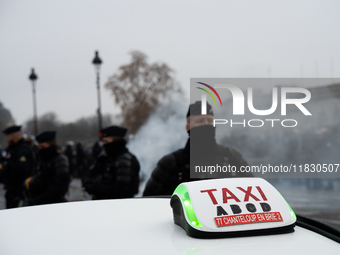 Taxi drivers gather at the Invalides in Paris, France, on December 3, 2024, during a demonstration against a new downward pricing system for...