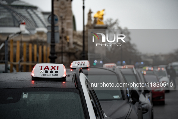 Taxi drivers gather at the Invalides in Paris, France, on December 3, 2024, during a demonstration against a new downward pricing system for...