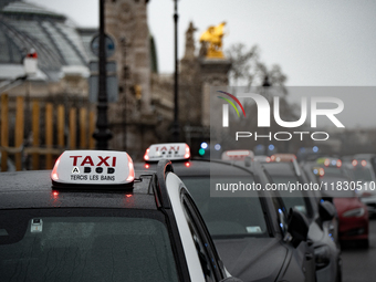 Taxi drivers gather at the Invalides in Paris, France, on December 3, 2024, during a demonstration against a new downward pricing system for...