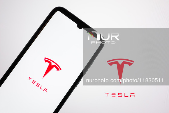 The Tesla logo appears on a smartphone screen and on a computer screen in this photo illustration in Athens, Greece, on December 3, 2024. (P...