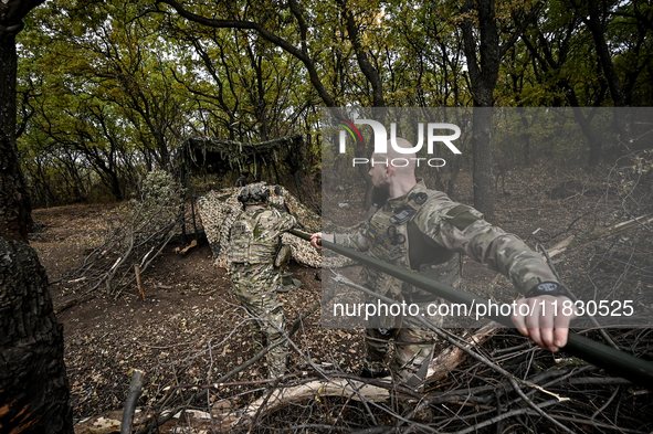 An artilleryman of the Khyzhak Patrol Police Special Unit cleans the barrel of a howitzer while on a combat mission at the positions in Done...