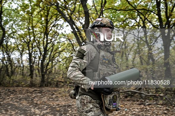 An artilleryman of the Khyzhak Patrol Police Special Unit holds an artillery shell case while on a combat mission at the positions in the Do...