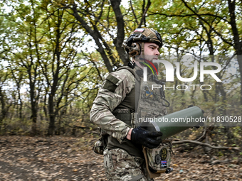 An artilleryman of the Khyzhak Patrol Police Special Unit holds an artillery shell case while on a combat mission at the positions in the Do...