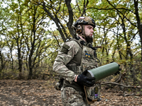 An artilleryman of the Khyzhak Patrol Police Special Unit holds an artillery shell case while on a combat mission at the positions in the Do...