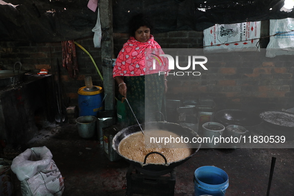 Workers prepare date palm jaggery before making ''Joynagar Moa of West Bengal,'' an Indian sweet made with folk rice mixed with date molasse...