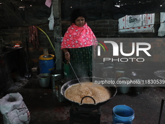 Workers prepare date palm jaggery before making ''Joynagar Moa of West Bengal,'' an Indian sweet made with folk rice mixed with date molasse...