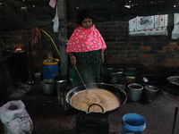 Workers prepare date palm jaggery before making ''Joynagar Moa of West Bengal,'' an Indian sweet made with folk rice mixed with date molasse...