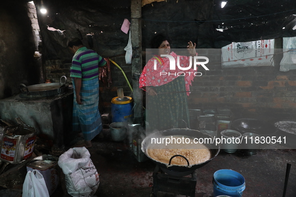 Workers prepare date palm jaggery before making ''Joynagar Moa of West Bengal,'' an Indian sweet made with folk rice mixed with date molasse...