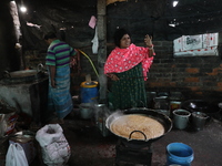 Workers prepare date palm jaggery before making ''Joynagar Moa of West Bengal,'' an Indian sweet made with folk rice mixed with date molasse...