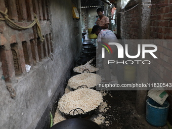 Workers prepare ''Joynagar Moa of West Bengal,'' an Indian sweet made with folk rice mixed with date molasses, inside a workshop at Jayanaga...