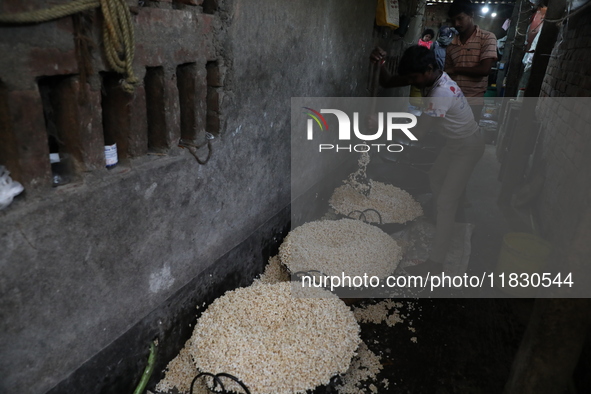 Workers prepare ''Joynagar Moa of West Bengal,'' an Indian sweet made with folk rice mixed with date molasses, inside a workshop at Jayanaga...