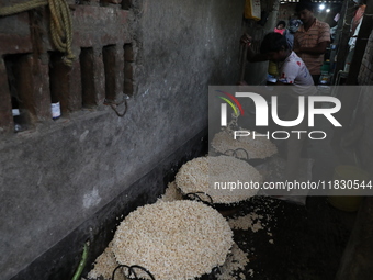 Workers prepare ''Joynagar Moa of West Bengal,'' an Indian sweet made with folk rice mixed with date molasses, inside a workshop at Jayanaga...