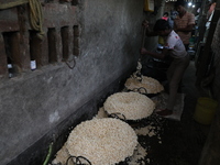 Workers prepare ''Joynagar Moa of West Bengal,'' an Indian sweet made with folk rice mixed with date molasses, inside a workshop at Jayanaga...