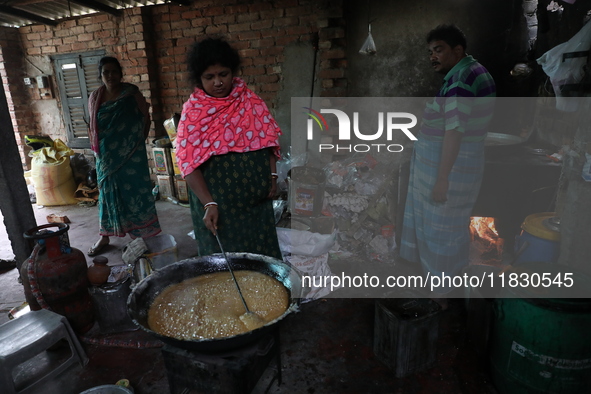 Workers prepare date palm jaggery before making ''Joynagar Moa of West Bengal,'' an Indian sweet made with folk rice mixed with date molasse...