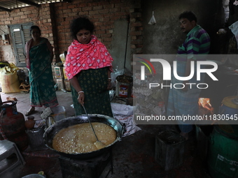 Workers prepare date palm jaggery before making ''Joynagar Moa of West Bengal,'' an Indian sweet made with folk rice mixed with date molasse...