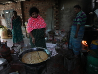 Workers prepare date palm jaggery before making ''Joynagar Moa of West Bengal,'' an Indian sweet made with folk rice mixed with date molasse...