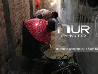 Workers prepare ''Joynagar Moa of West Bengal,'' an Indian sweet made with folk rice mixed with date molasses, inside a workshop at Jayanaga...