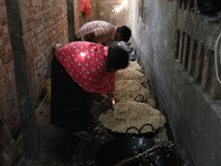 Workers prepare ''Joynagar Moa of West Bengal,'' an Indian sweet made with folk rice mixed with date molasses, inside a workshop at Jayanaga...