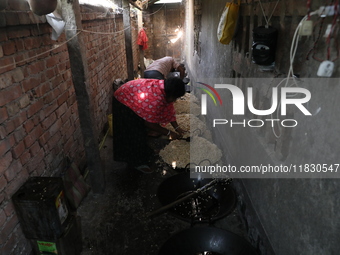 Workers prepare ''Joynagar Moa of West Bengal,'' an Indian sweet made with folk rice mixed with date molasses, inside a workshop at Jayanaga...