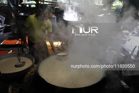 Workers prepare date palm jaggery before making ''Joynagar Moa of West Bengal,'' an Indian sweet made with folk rice mixed with date molasse...