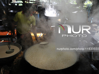 Workers prepare date palm jaggery before making ''Joynagar Moa of West Bengal,'' an Indian sweet made with folk rice mixed with date molasse...