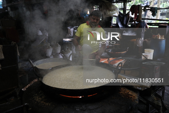 Workers prepare date palm jaggery before making ''Joynagar Moa of West Bengal,'' an Indian sweet made with folk rice mixed with date molasse...