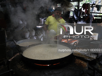 Workers prepare date palm jaggery before making ''Joynagar Moa of West Bengal,'' an Indian sweet made with folk rice mixed with date molasse...