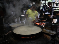 Workers prepare date palm jaggery before making ''Joynagar Moa of West Bengal,'' an Indian sweet made with folk rice mixed with date molasse...