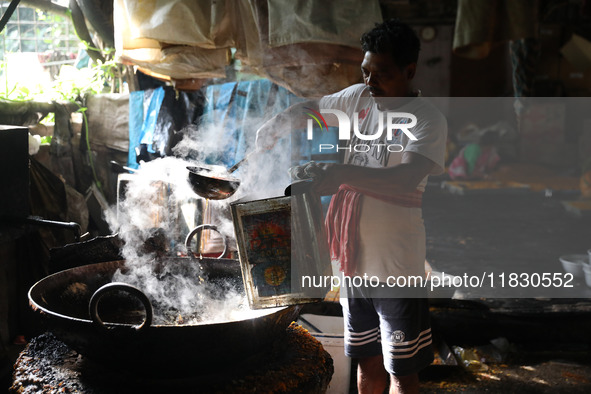 A worker prepares date palm jaggery before making ''Joynagar Moa of West Bengal,'' an Indian sweet made with folk rice mixed with date molas...