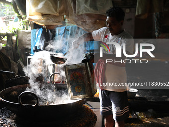 A worker prepares date palm jaggery before making ''Joynagar Moa of West Bengal,'' an Indian sweet made with folk rice mixed with date molas...