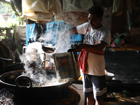 A worker prepares date palm jaggery before making ''Joynagar Moa of West Bengal,'' an Indian sweet made with folk rice mixed with date molas...