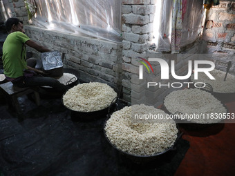 A worker prepares ''Joynagar Moa of West Bengal,'' an Indian sweet made with folk rice mixed with date molasses, inside a workshop at Jayana...