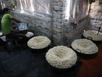 A worker prepares ''Joynagar Moa of West Bengal,'' an Indian sweet made with folk rice mixed with date molasses, inside a workshop at Jayana...