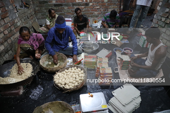 Workers prepare ''Joynagar Moa of West Bengal,'' an Indian sweet made with folk rice mixed with date molasses, inside a workshop at Jayanaga...