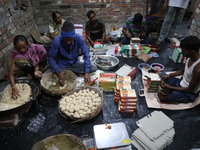 Workers prepare ''Joynagar Moa of West Bengal,'' an Indian sweet made with folk rice mixed with date molasses, inside a workshop at Jayanaga...