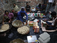 Workers prepare ''Joynagar Moa of West Bengal,'' an Indian sweet made with folk rice mixed with date molasses, inside a workshop at Jayanaga...