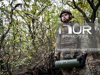 An artilleryman of the Khyzhak Patrol Police Special Unit holds an artillery shell case while on a combat mission at the positions in the Do...