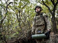 An artilleryman of the Khyzhak Patrol Police Special Unit holds an artillery shell case while on a combat mission at the positions in the Do...