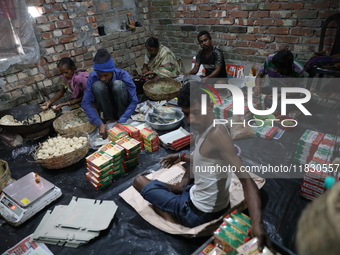 Workers prepare ''Joynagar Moa of West Bengal,'' an Indian sweet made with folk rice mixed with date molasses, inside a workshop at Jayanaga...