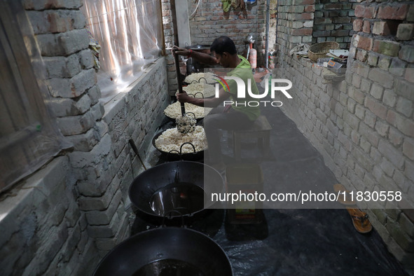 A worker prepares ''Joynagar Moa of West Bengal,'' an Indian sweet made with folk rice mixed with date molasses, inside a workshop at Jayana...