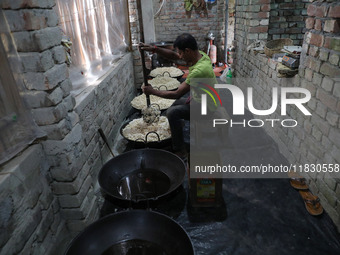 A worker prepares ''Joynagar Moa of West Bengal,'' an Indian sweet made with folk rice mixed with date molasses, inside a workshop at Jayana...