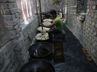 A worker prepares ''Joynagar Moa of West Bengal,'' an Indian sweet made with folk rice mixed with date molasses, inside a workshop at Jayana...