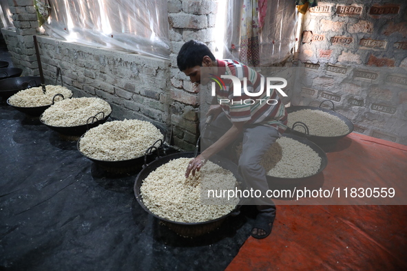 A worker prepares ''Joynagar Moa of West Bengal,'' an Indian sweet made with folk rice mixed with date molasses, inside a workshop at Jayana...