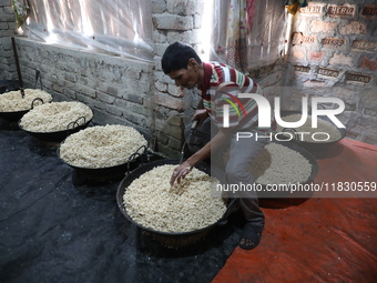 A worker prepares ''Joynagar Moa of West Bengal,'' an Indian sweet made with folk rice mixed with date molasses, inside a workshop at Jayana...