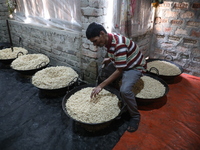 A worker prepares ''Joynagar Moa of West Bengal,'' an Indian sweet made with folk rice mixed with date molasses, inside a workshop at Jayana...